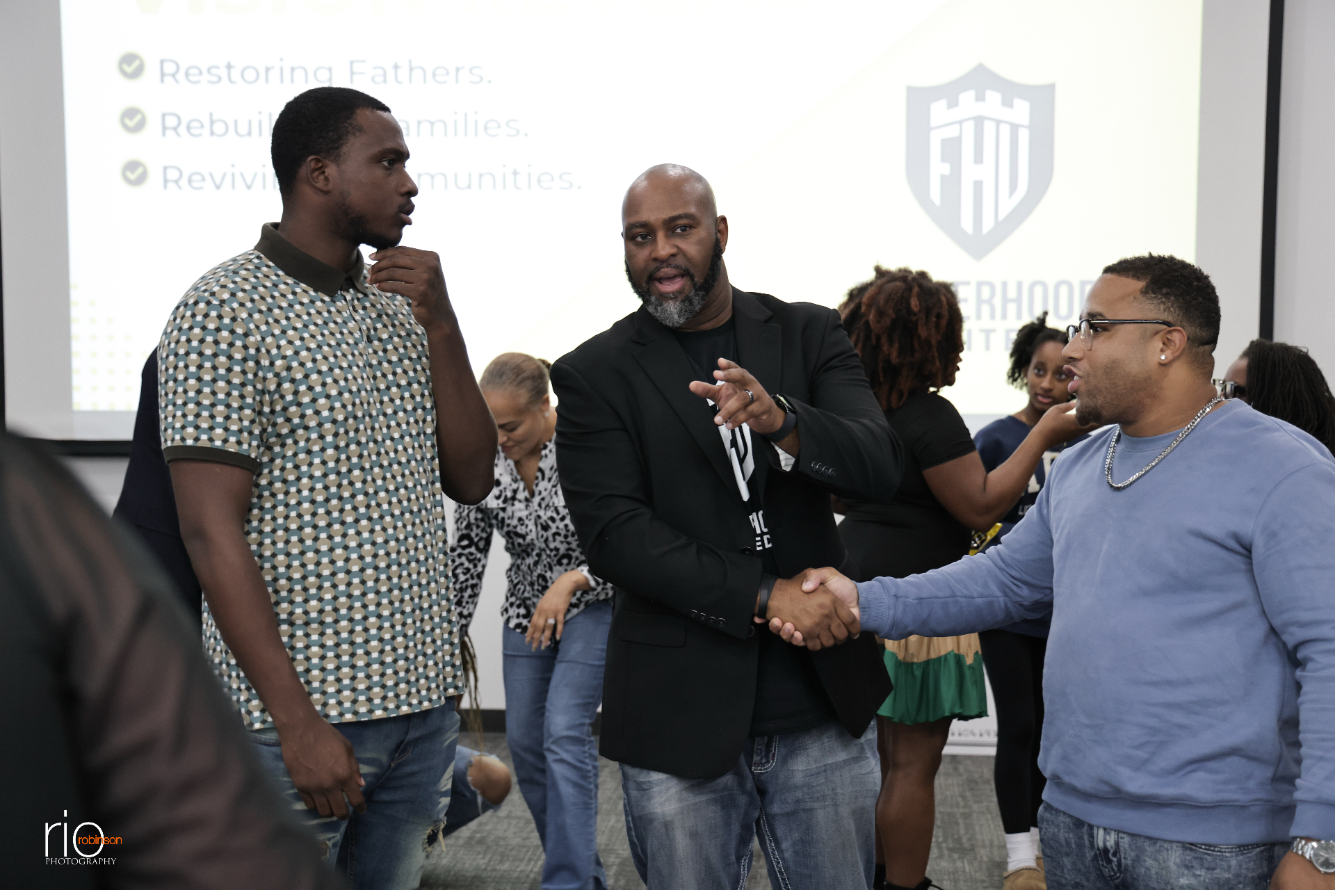 TC Bell connecting with two men at a Fatherhood United event